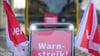 Ein Schild „Warnstreik“ steht vor einem Bus.