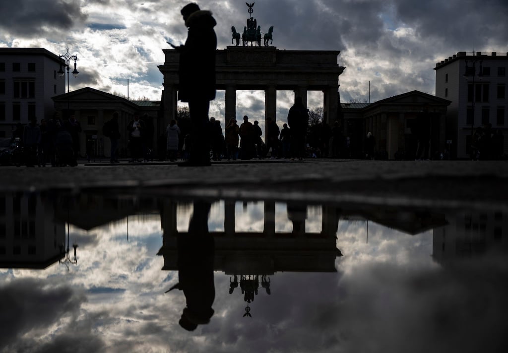 Das Brandenburger Tor spiegelt sich nach dem Regen in einer Pfütze.