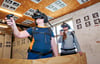 Es rüttelt und schwankt mächtig: Per VR-Brillen wird der Feuerwehreinsatz auf einer Drehleiter simuliert. Sharon und Jonathan finden es cool.  Die Ausbildung des  Feuerwehrnachwuchses ist eines von zahlreichen  Angeboten in der Zeitzer Nudelfabrik. 