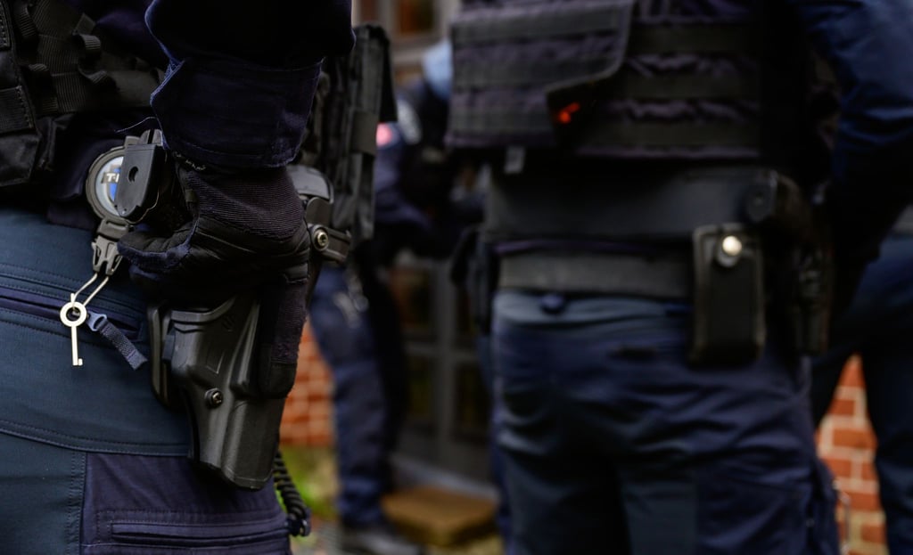Ein Polizist der Verfügungseinheit aus Lüneburg hat seine Hand an der Dienstwaffe vom Typ SFP9.