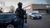 Maskierte und bewaffnete niederländische Polizisten bewachen einen Transport mit einigen der Verdächtigen, die vor dem Hochsicherheitsgebäude des Gerichts in Amsterdam eintreffen.