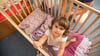 Bevor es Zeit fürs große Bett wird, können übergangsweise zwei Gitterstäben entfernt werden, damit das Kind selbstständig aus- und einsteigen kann.