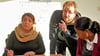Kim Hartwig (Mitte), Ausbilder bei der Straßenverkehrs-Genossenschaft Bremen eG, hilft Migrantinnen beim Theorieunterricht für den Führerschein.