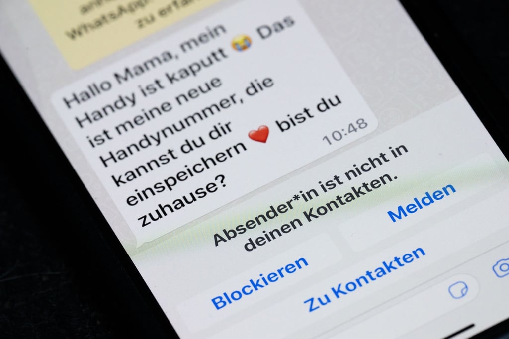 Auf dem Display eines Smartphones steht eine Whats App-Nachricht, die im Tonfall betrügerischen Nachrichten nachempfunden ist.