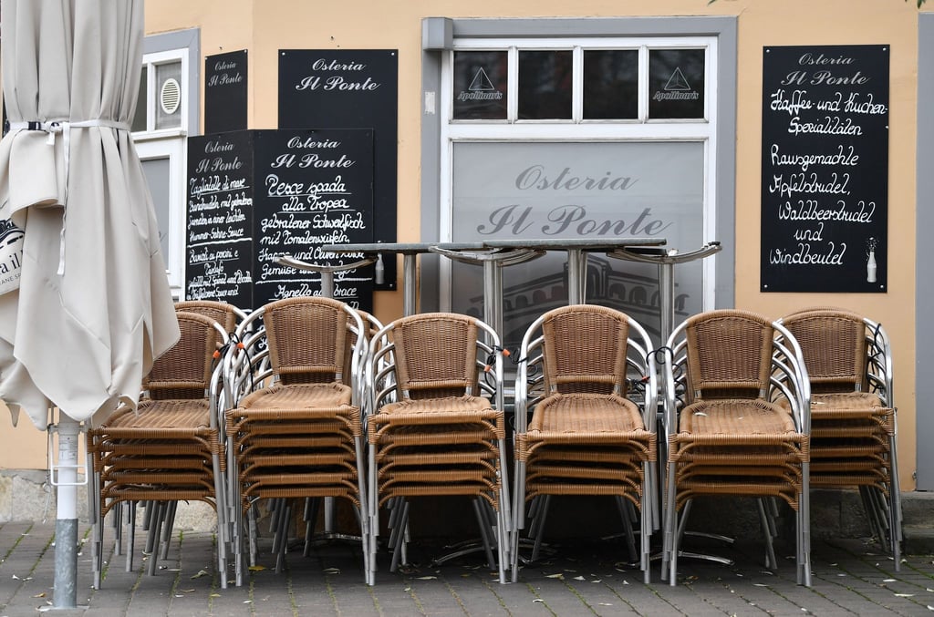 Die Stühle und Tische für den Außenbereich eines Restaurants sind übereinander gestapelt.