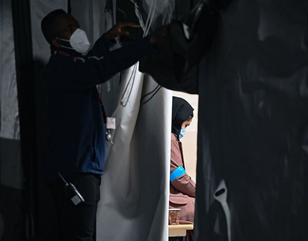 Eine geflüchtete Frau sitzt in einem Zelt der DRK-Flüchtlingshilfe in der Erstaufnahmeeinrichtung in Doberlug-Kirchhain.