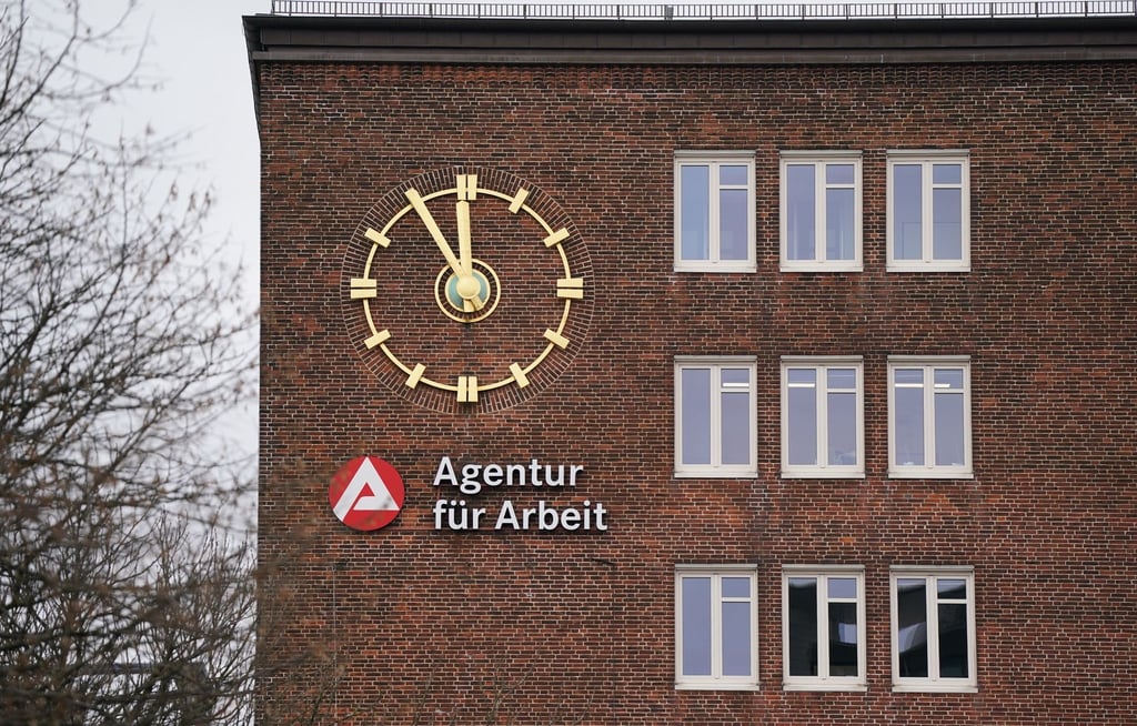 Die Uhr an der Fassade der Agentur für Arbeit zeigt fünf Minuten vor Zwölf an.