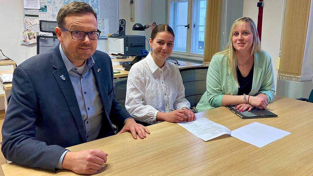 Ulrike Nestmann (M.) unterschreibt im Beisein von Bürgermeister Axel Clauß und Ausbildungsleiterin Marie Matthes ihren Ausbildungsvertrag.