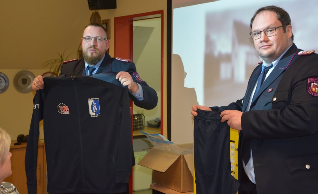 Chrstian Werner (l.) vom Förderverein der Freiwilligen Feuerwehr Elbenau übergibt die vom Verein gespendeten Kleidungssätze. Diese sind vor allem für die Atemschutzgeräteträger gedacht, damit sie sich direkt nach dem Einsatz umziehen und die kontaminierte Einsatzkleidung ablegen können.