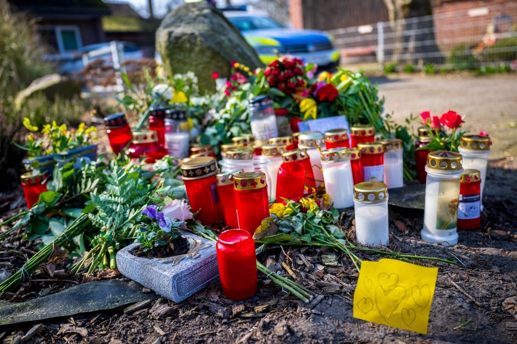Blumen und Kerzen liegen vor einem Einfamilienhaus.