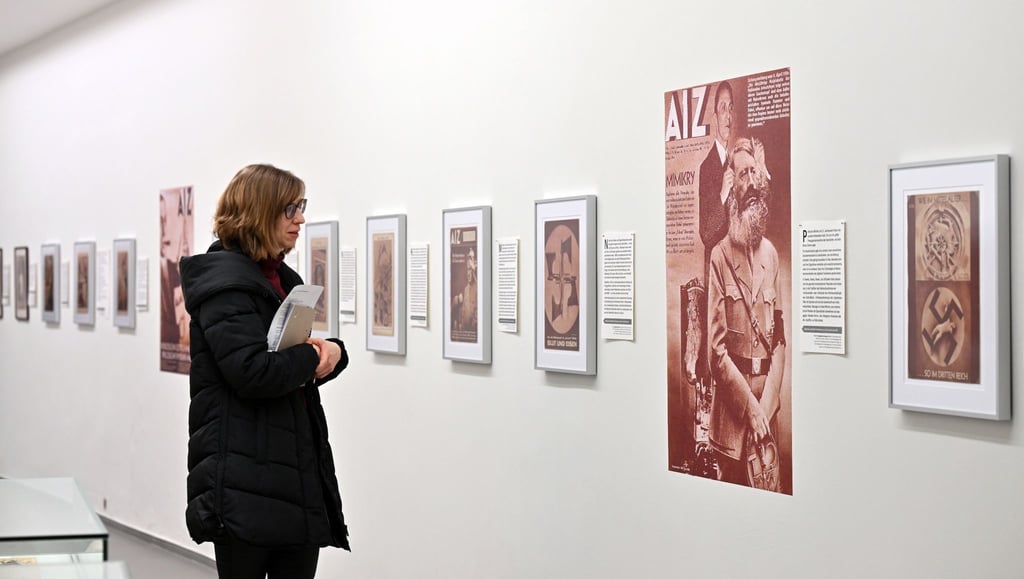 Eine Frau betrachtet die Ausstellung „33 Geistesblitze. Antifaschistische Fotomontagen von John Heartfield, 2024 neu gelesen“.