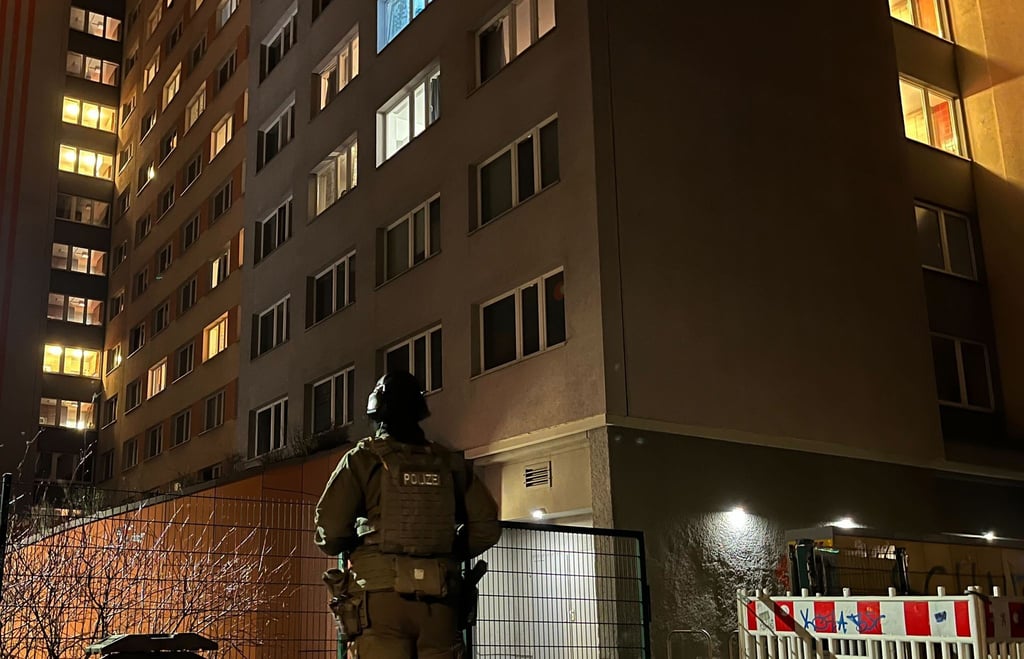 Ein Polizist steht vor einem Hochhaus in Berlin-Friedrichshain.