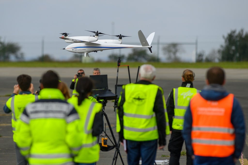 Eine Drohne landet im Nationalen Erprobungszentrum für unbemannte Luftfahrtsysteme nach dem Testflug vor Mitarbeitern des Instituts für Optische Sensorsysteme des Deutschen Zentrum für Luft- und Raumfahrt (DLR).