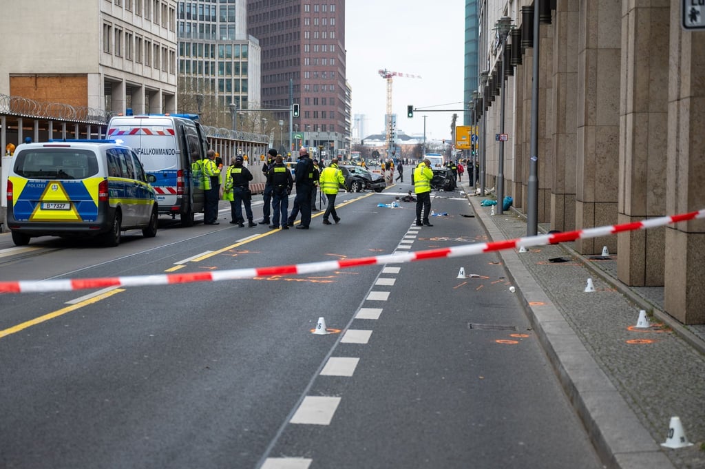 Polizisten stehen an einer Unfallstelle in der Leipziger Straße.