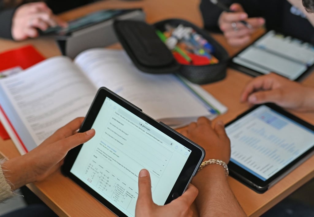 Realschüler einer zehnten Klasse arbeiten in einer Unterrichtsstunde mit Tablets.