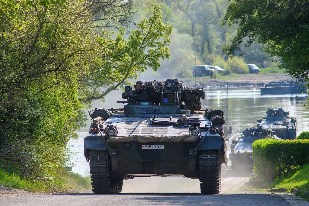 Schützenpanzer "Marder" rollen von einer Schwimmschnellbrücke an Land.