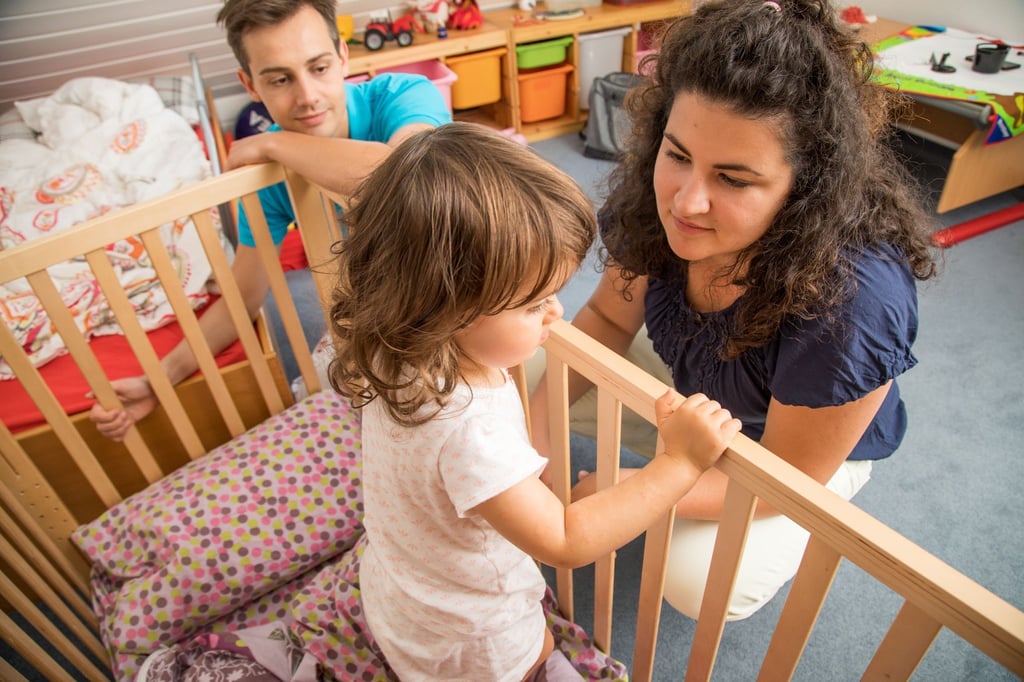 Wenn Eltern merken, dass es Zeit ist, das Gitterbett hinter sich zu lassen, sollten sie das Kind einbeziehen und den Umzug erklären.