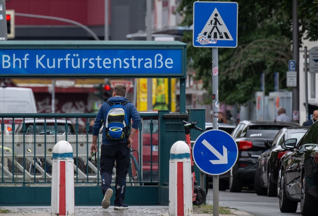 Ein Mann geht über die Kurfürstenstraße zu dem Eingang zur gleichnamigen U-Bahnstation.