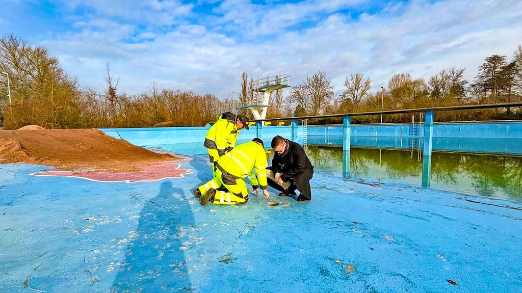 Die Bodenplatte des alten Beckens soll das auch neue Becken tragen. Bürgermeister Matthias Egert (r.) spricht mit Bauleuten über Probebohrungen im Beton.