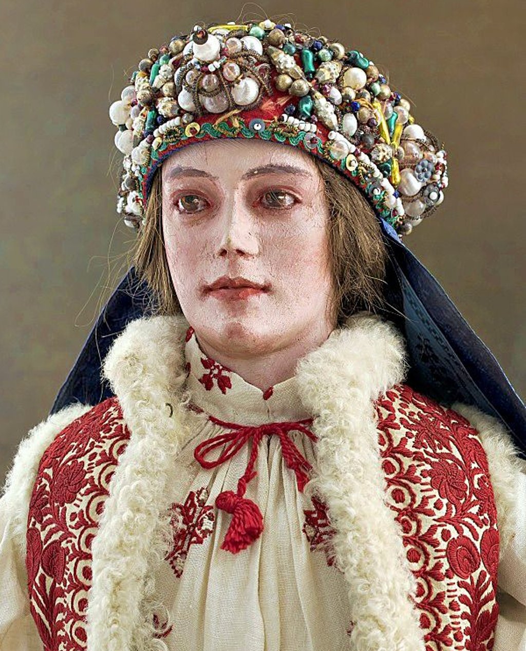Dieses Bild zeigt eine Puppe in ungarischer Tracht mit auffälligem, detailreichem Kopfschmuck.