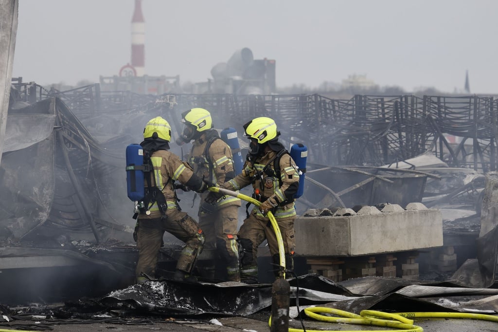 Die Feuerwehr löscht die Brandstelle bei Flüchtlingsunterkunft am ehemaligen Flughafen Tegel.