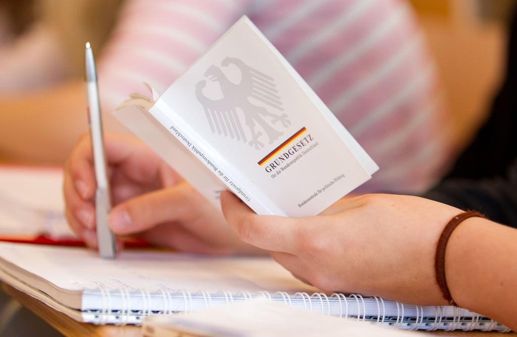 Eine Jura-Studentin hält in einer Vorlesung an der Universität Osnabrück eine Ausgabe vom Grundgesetz in der Hand.