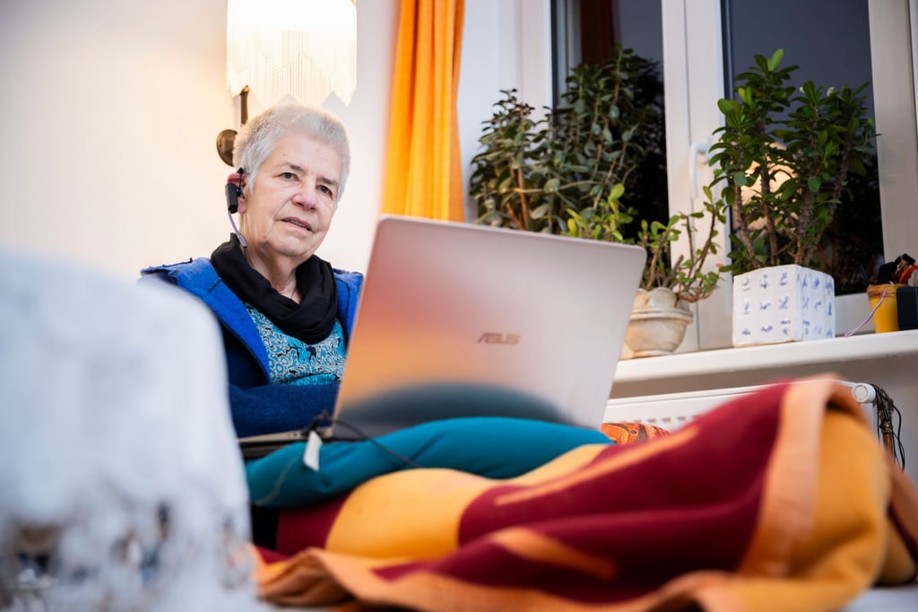 Elke Schilling, Gründerin von Silbernetz, telefoniert im Homeoffice auf ihrem Sofa sitzend von ihrer Berliner Wohnung aus.