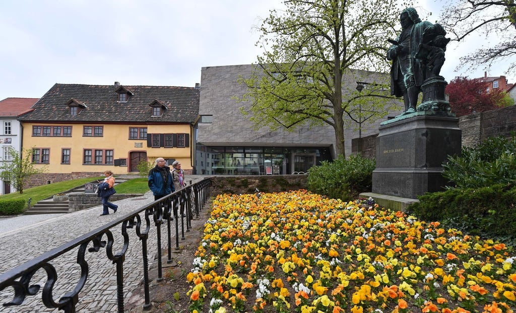 Besucher besichtigen das Bachdenkmal vor dem Bachhaus in Eisenach.