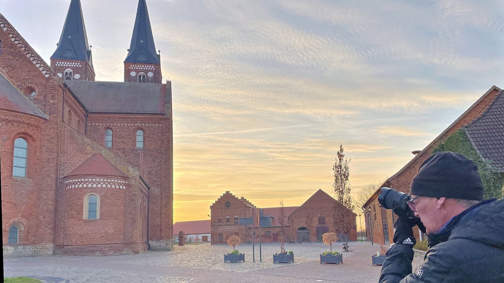 Ein Tourist fotografiert das Kloster Jerichow im Abendlicht.
