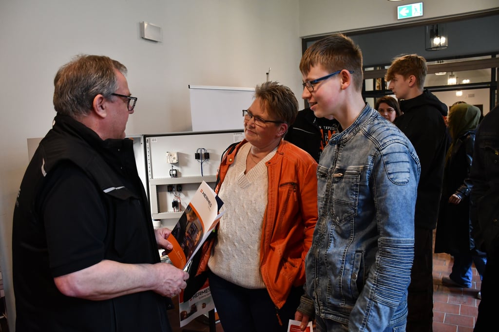 Adrian und seine Mutter Nina Lippelt informieren sich am Stand von Hermes Systeme Oschersleben bei Geschäftsführer Stefan Zydorek über mögliche Ausbildungsberufe.