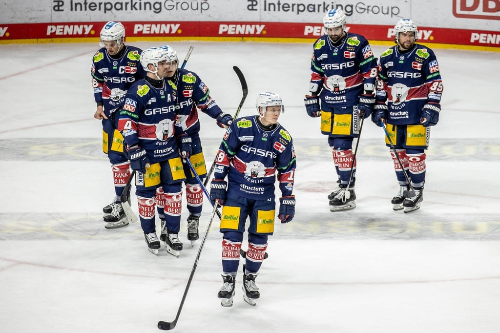 Spieler der Eisbären Berlin laufen nach der Niederlage enttäuscht über das Eis.