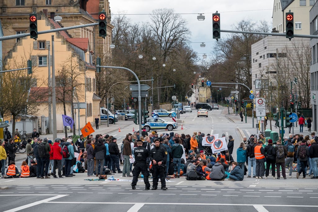 Aktivistinnen und Aktivisten der Letzten Generation blockieren eine Kreuzung in Regensburg.