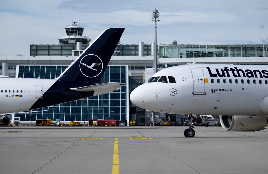 Flugzeuge der Lufthansa stehen am Flughafen auf dem Rollfeld.