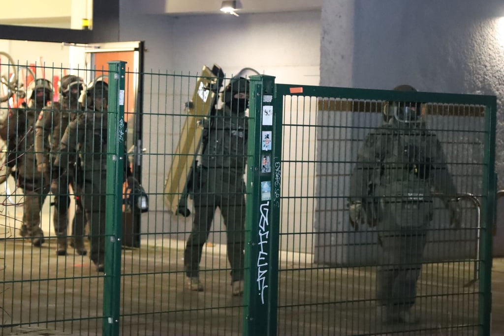 Polizisten in Spezialausrüstung verlassen ein Hochhaus in Berlin-Friedrichshain.