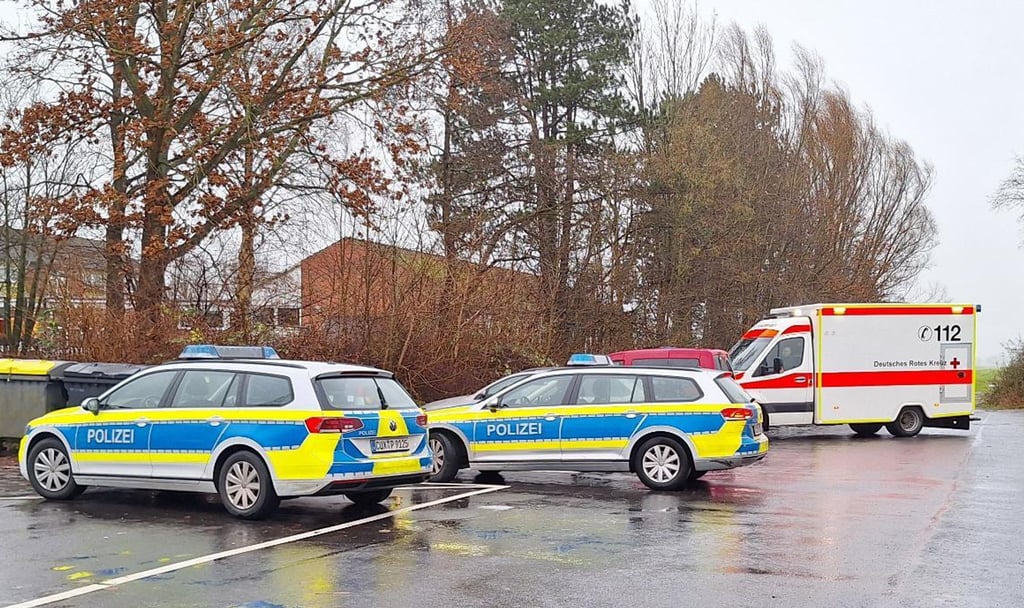 Polizeiautos und ein Krankenwagen stehen nahe einer Schule.