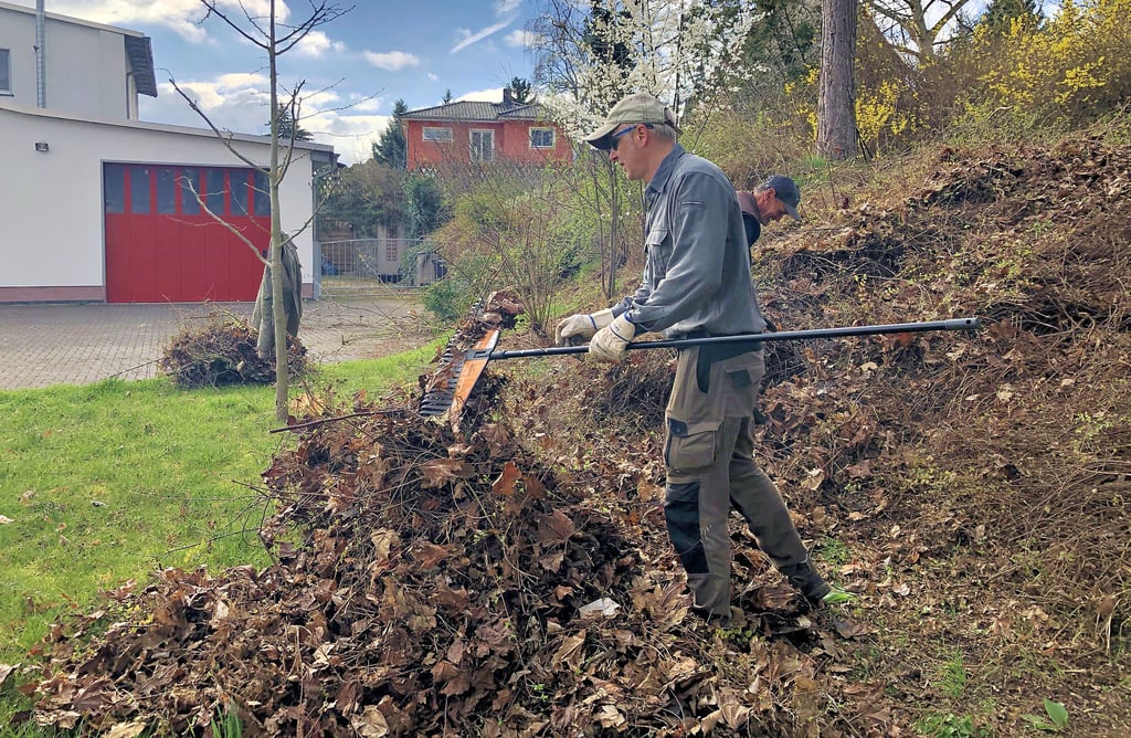 Dirk Noack und Thomas Henschel arbeiten an den Grünanlagen am Platz der Feuerwehr in Krumpa. Sie beseitigen Laub und Wildwuchs.