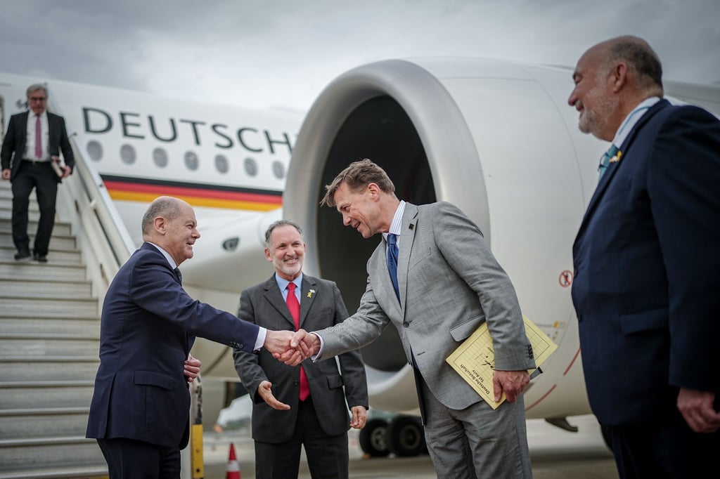 Kanzler Scholz wird auf dem Flughafen von Tel Aviv vom deutschen BOtschafter Steffen Seibert begrüßt. Rechts der israelische Botschafter in Deutschland, Ron Prosor.
