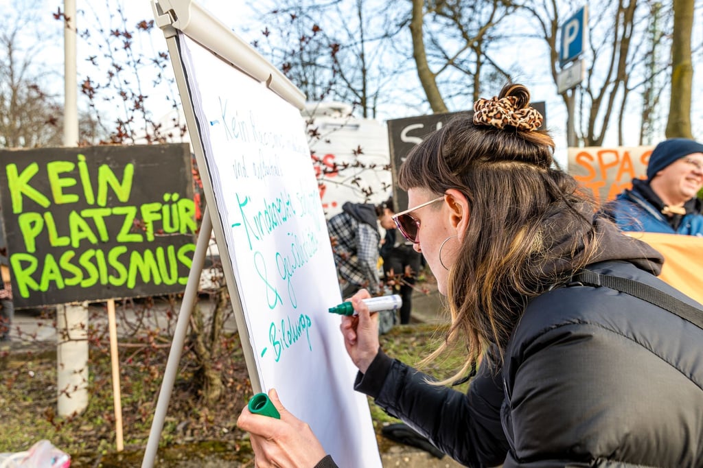 „Kein Platz für Rassismus“ steht auf einem Schild bei einer Demonstration vor dem Cottbuser Schulamt.