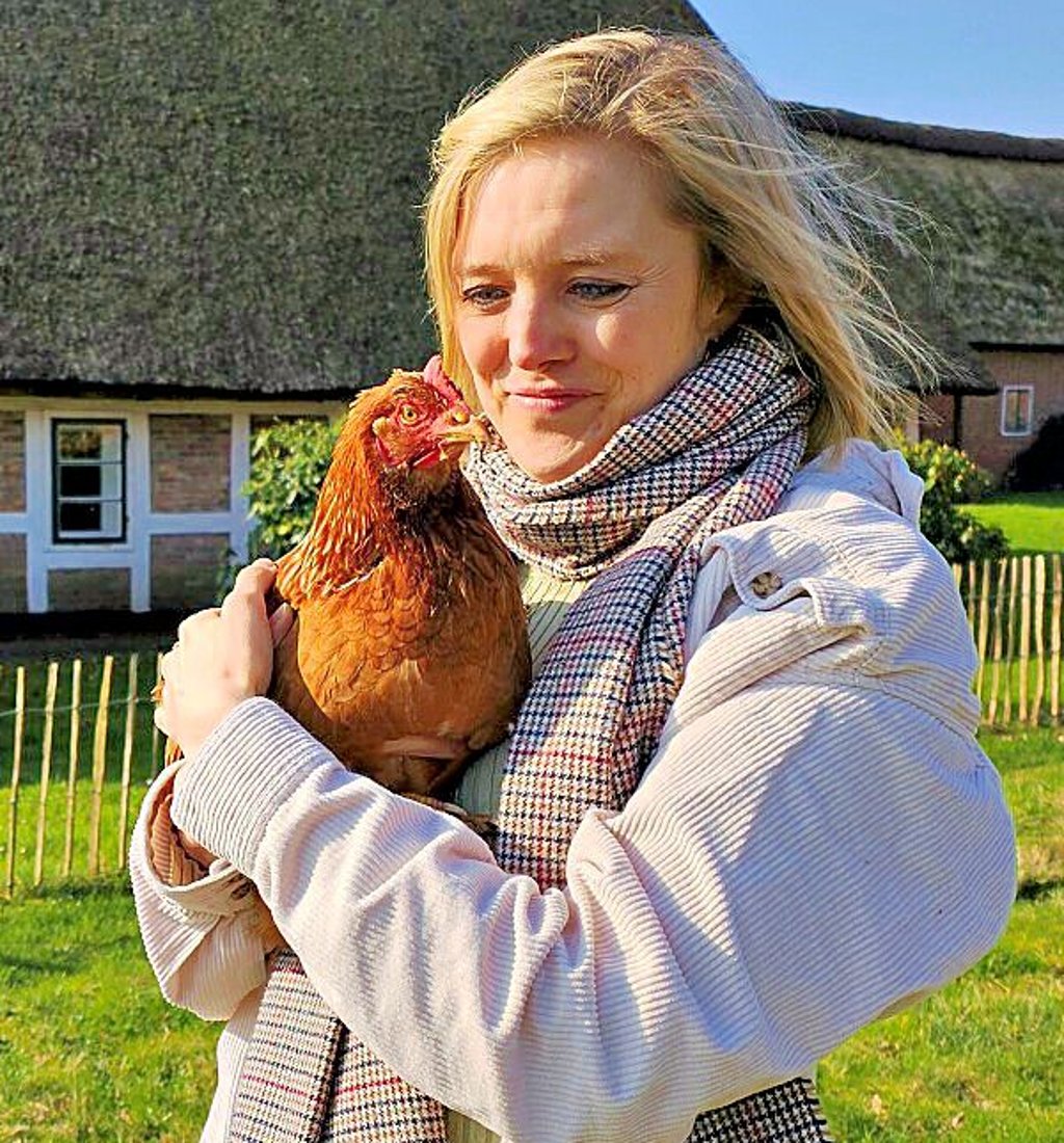 Ulrike Kohl mit Legehenne Emmi neun Monate nach der Übernahme durch den Verein "Rettet das Huhn"