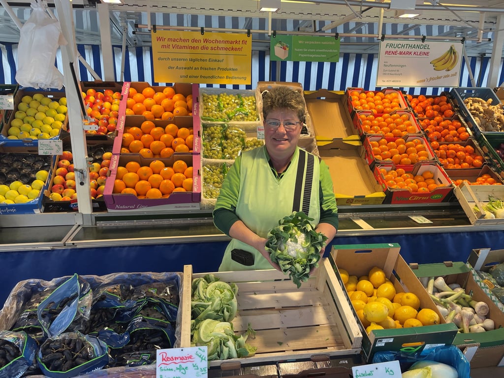 Diana Kleine hält einen Blumenkohl in der Hand, den sie auf dem Wochenmarkt in Weißenfels verkauft.