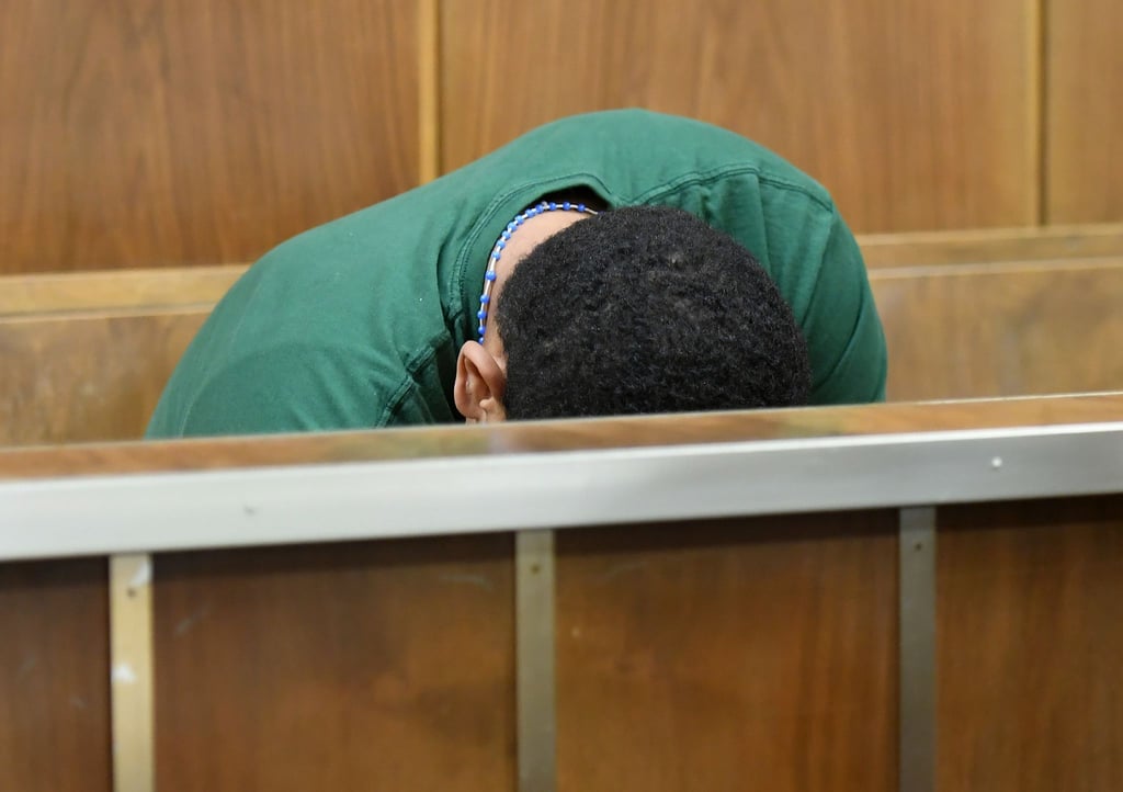 Der Angeklagte sitzt in einem Gerichtssaal im Landgericht Hannover und hält den Kopf gesenkt.