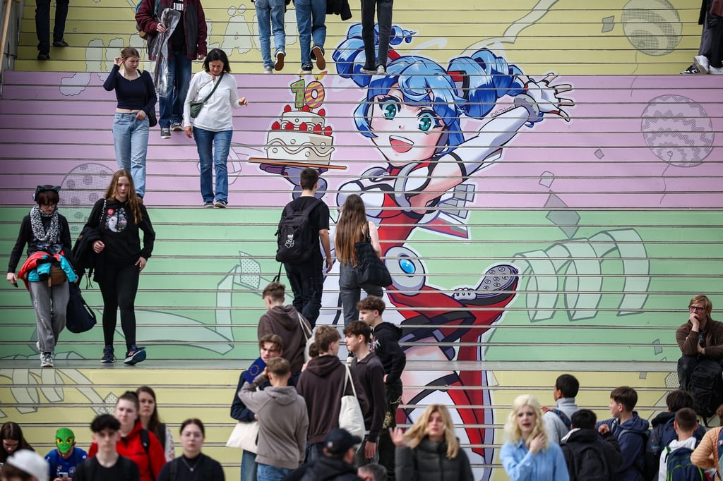 Besucher gehen über eine Treppe mit einem Manga-Motiv zum 10. Jubiläum der Manga-Comic-Con auf der Leipziger Buchmesse.