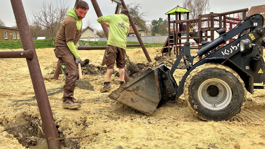 Die Bauarbeiter betonieren die neuen Spielelemente auf dem Kinderspielplatz in Heteborn ein.