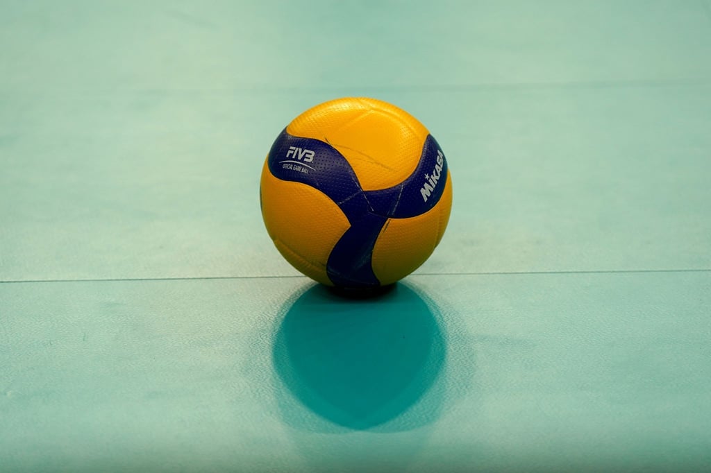 Ein Volleyball liegt auf dem Hallenboden.