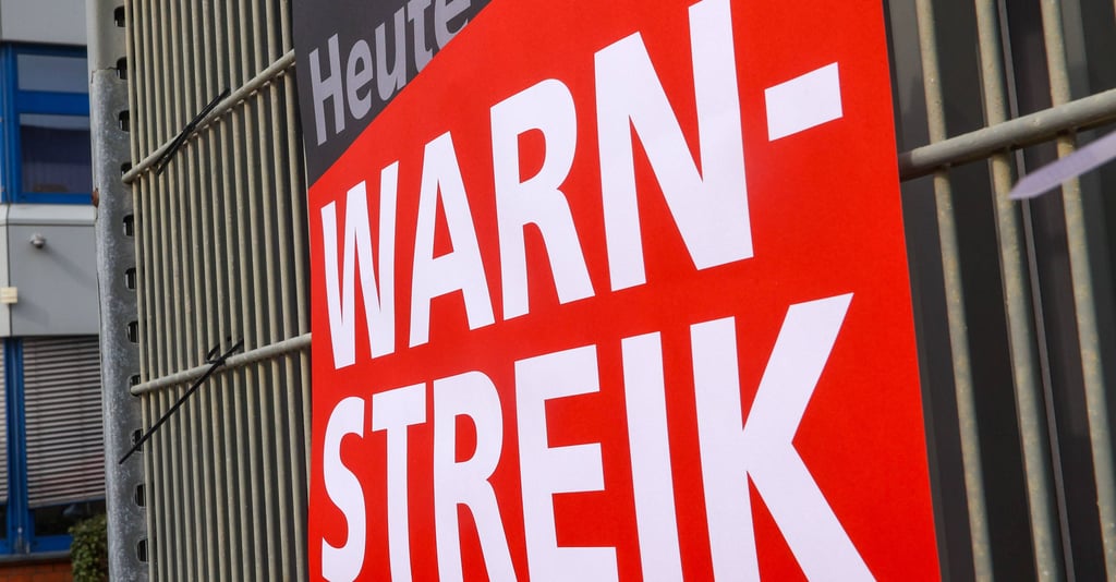 Ein Schild mit der Aufschrift Warnstreik. In Magdeburg streiken die Bus. und Straßenbahnfahrer.