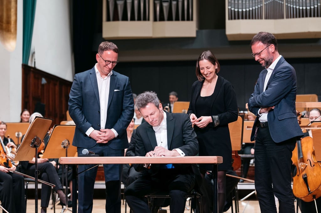 Simon Gaudenz (2.v.l) unterzeichnet seine Vertragsverlängerung als Generalmusikdirektor bei der Jenaer Philharmonie.
