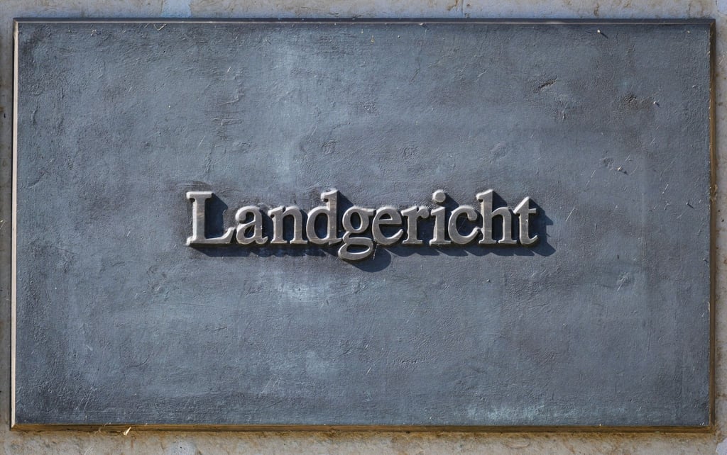 Ein Schild ist am Justizzentrum Dresden montiert.