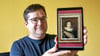 Reik Rupietta vom Förderverein Anhaltische Gemäldegalerie und Georgengarten mit einem Foto des Gemäldes von Ludwig XIII., das dringend Hilfe braucht.
