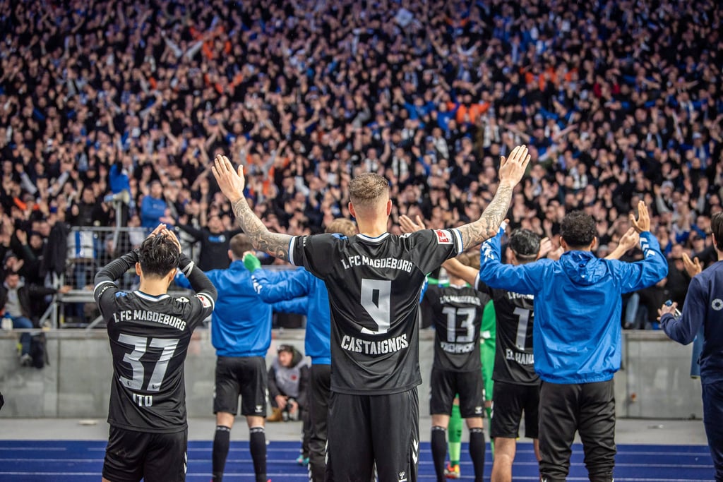 Die Spieler des 1. FC Magdeburg vor der Fankurve.