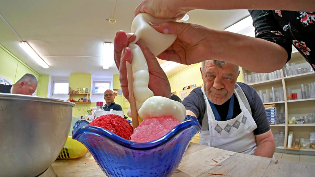 Neue Kreation: Frank Domeyer (re.) hat die „Sahne“ geschlagen, die auf den Kerzen-Eisbecher kommt und dann nach Laune dekoriert wird.